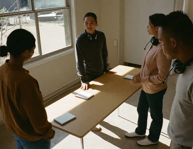 Four colleagues talking around a table in a bright office